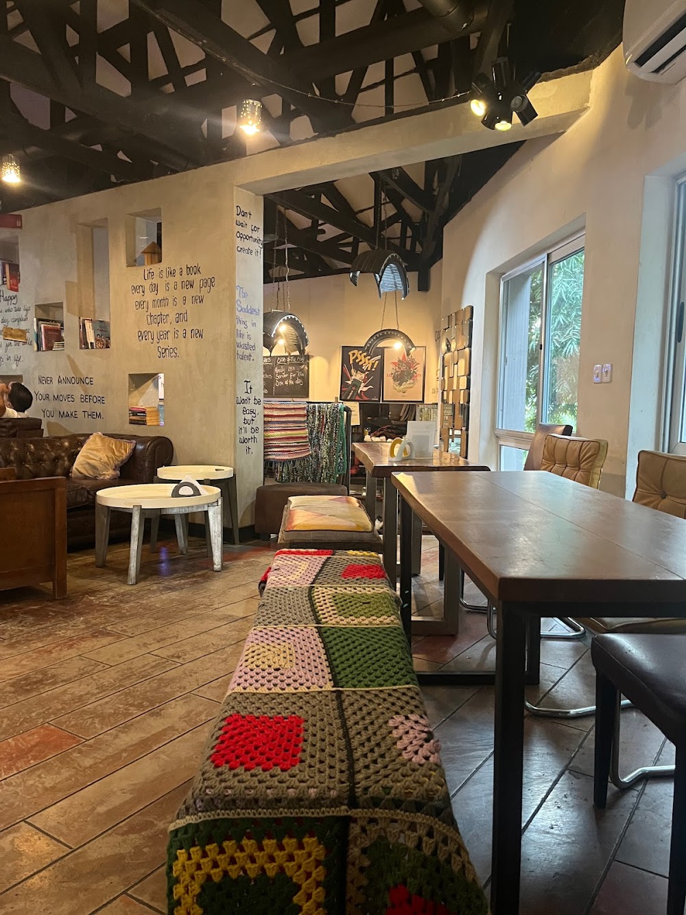 Warm and inviting interior of Café de Vie with wooden furniture, plants and happy guests
